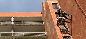 Rapelling down the side of a brick building